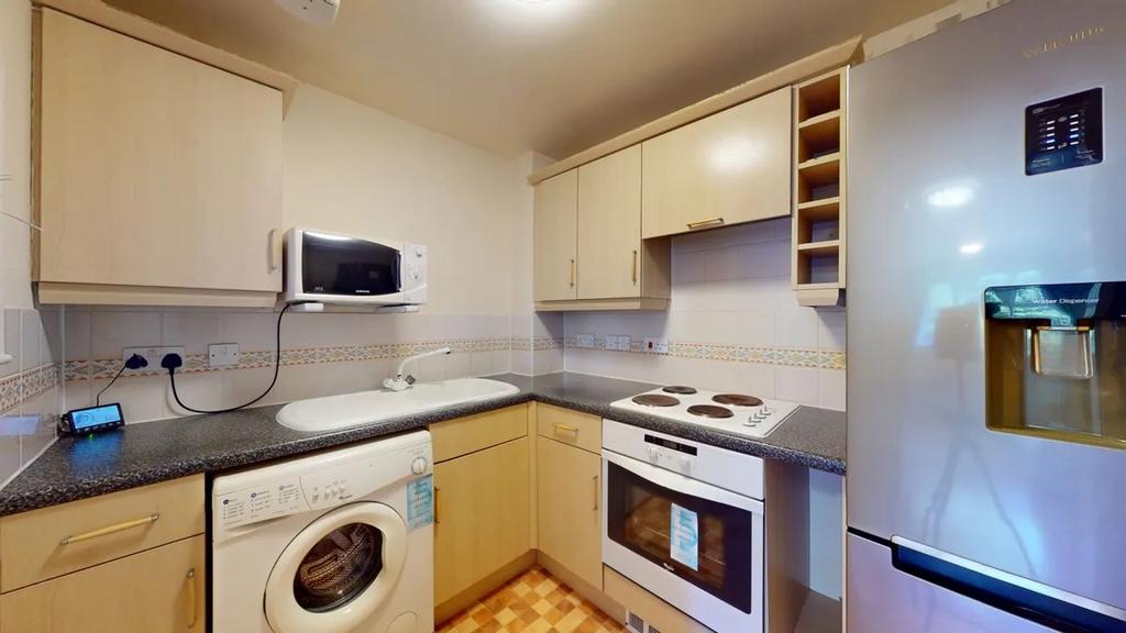 Modern fitted kitchen with light wood cabinets,...