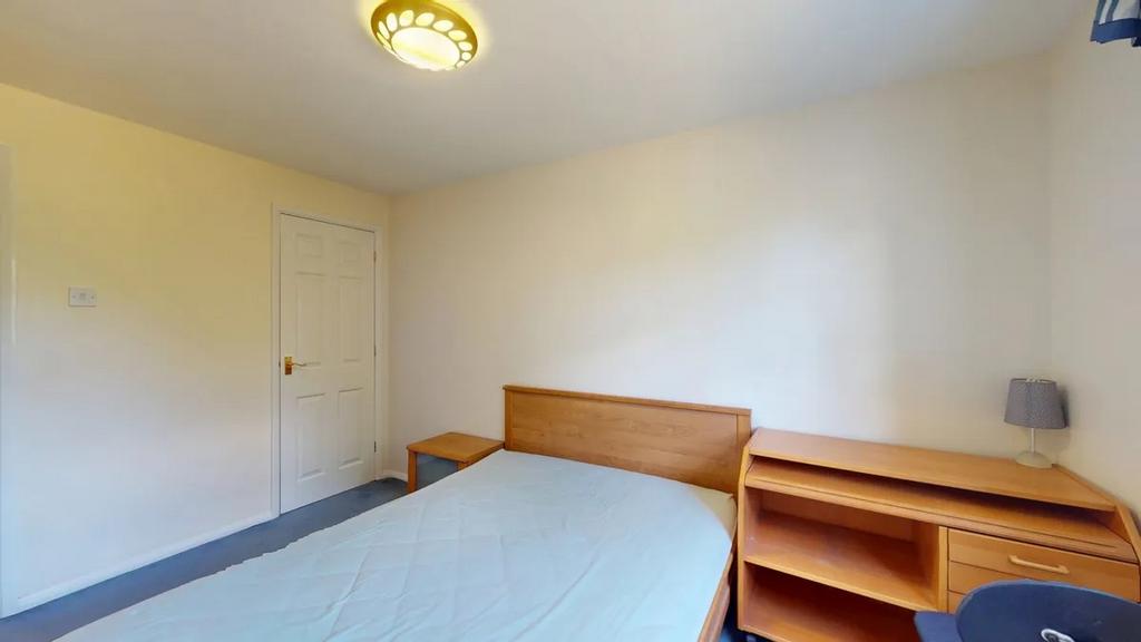 Bright, neatly presented bedroom with a wooden ...