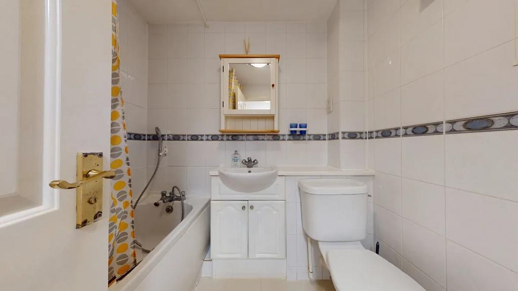 Bright, well-maintained bathroom with a white s...