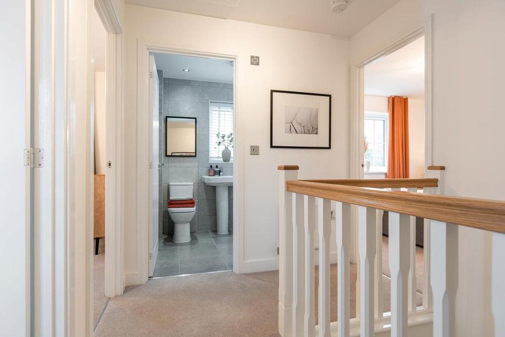 The central staircase leads up to a bright landing