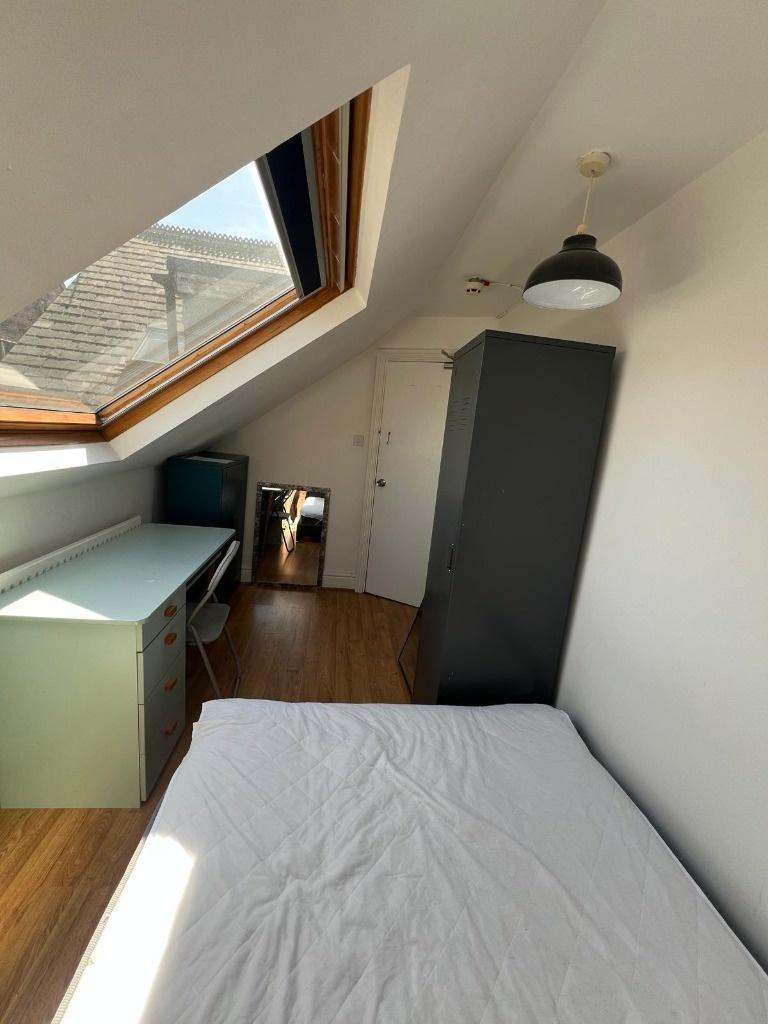 Bright attic single bedroom with a large skylig...