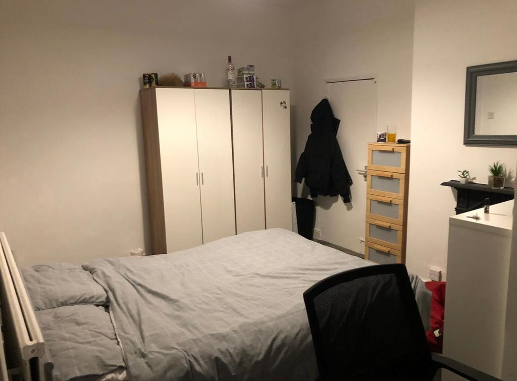 Cozy double bedroom with a neatly made bed, fre...