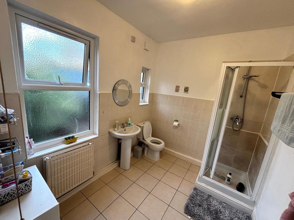 Bright, tiled bathroom with a separate shower c...