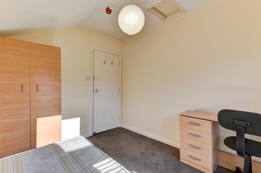 A neat and well-lit bedroom with a comfortable ...