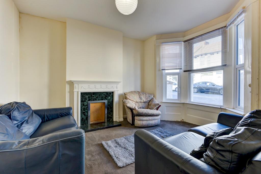 Bright bay-fronted living room with a decorativ...