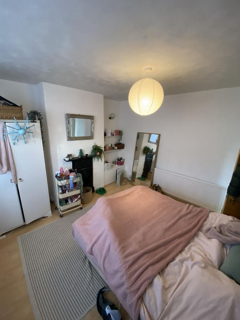 Bright, cozy bedroom with soft pink bedding, a ...