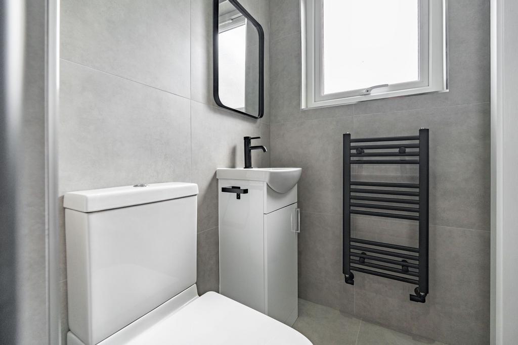 Modern bathroom featuring a sleek toilet, a sma...