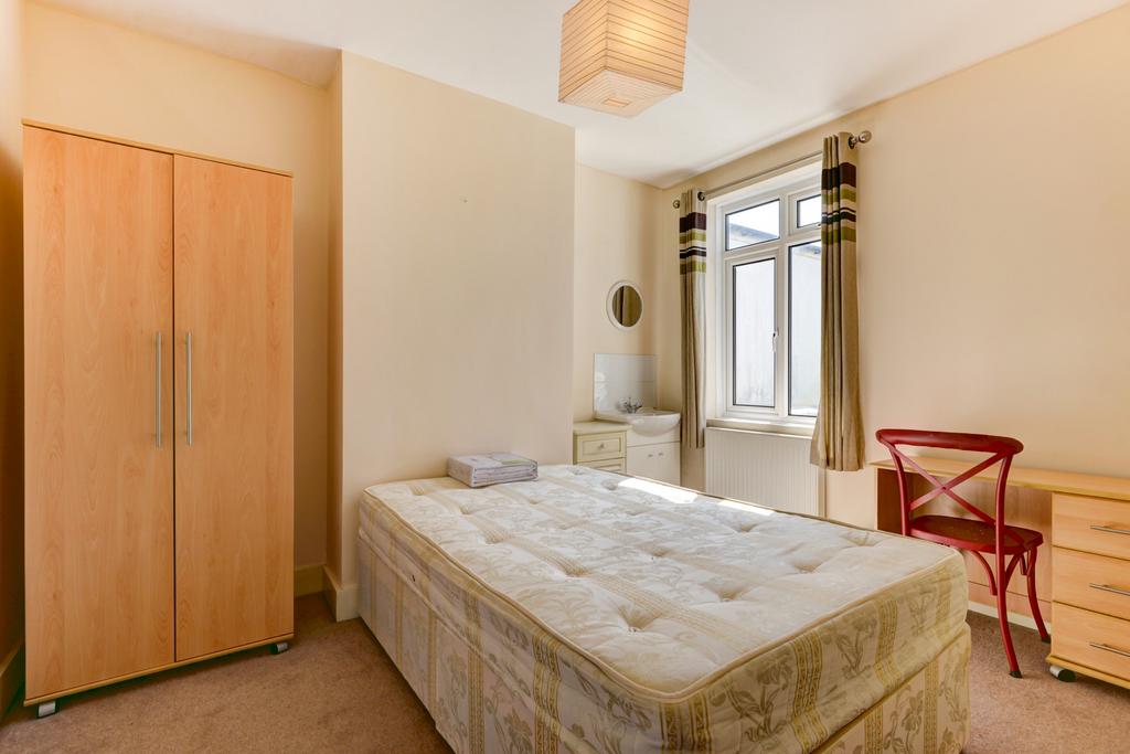 A cozy bedroom featuring a single bed and a war...