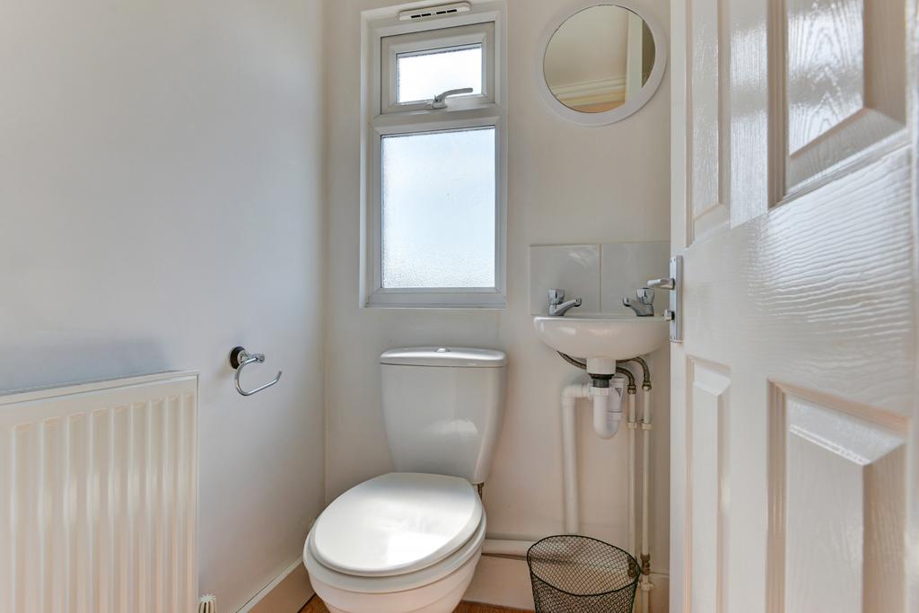 Bright, well-maintained bathroom with white san...