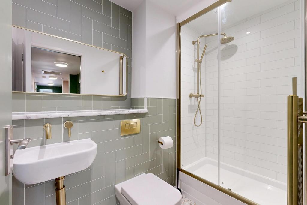 Bright, modern bathroom with a glass-enclosed s...