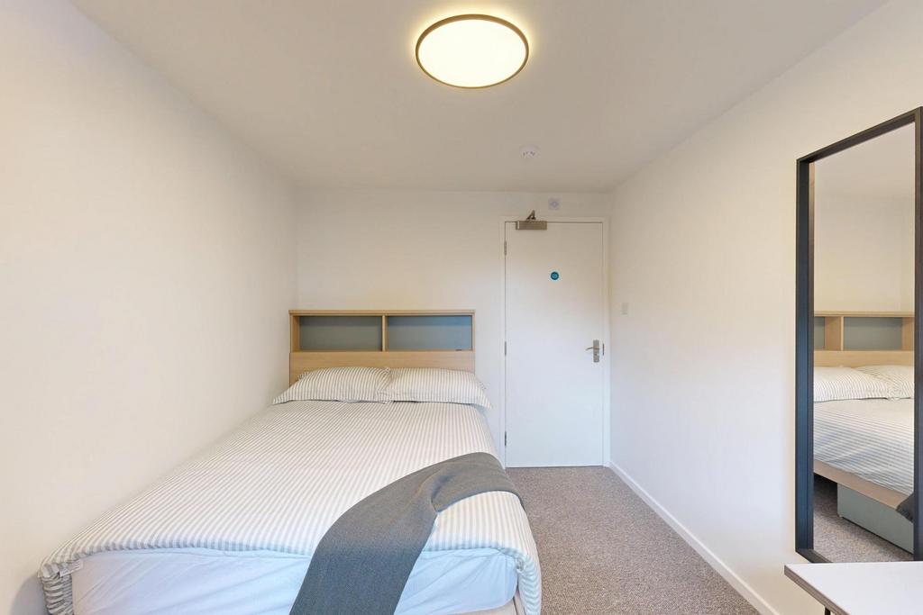 Neat, simply furnished bedroom with a comfortab...