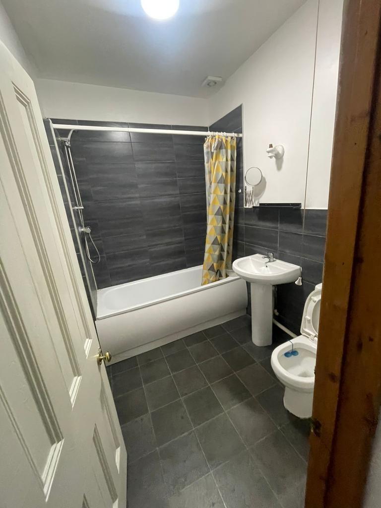 Modern bathroom with a white bathtub, pedestal ...