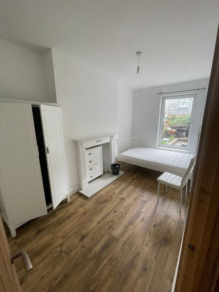 Bright, simply furnished bedroom with wood-effe...