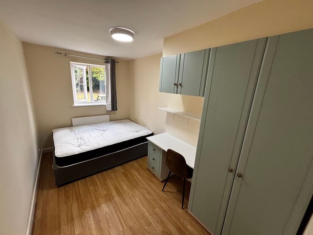 A cozy single bedroom featuring a comfortable b...