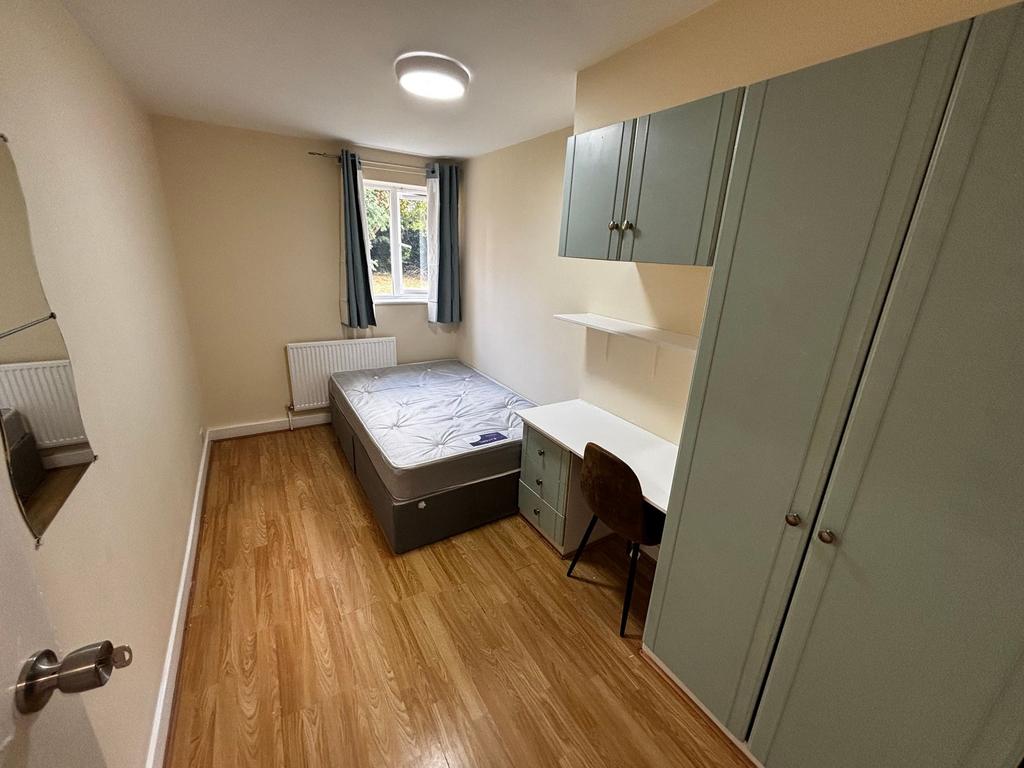 A cozy single bedroom with a tidy bed, ample na...