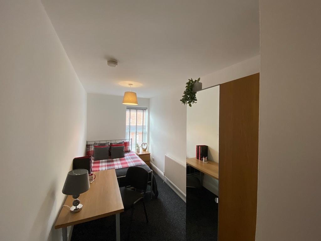 Bright, neatly furnished double bedroom with a ...