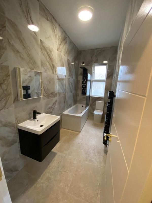 Modern, well-maintained bathroom featuring a sl...