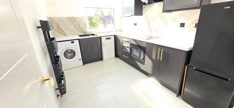 Modern kitchen with sleek dark cabinetry, ample...