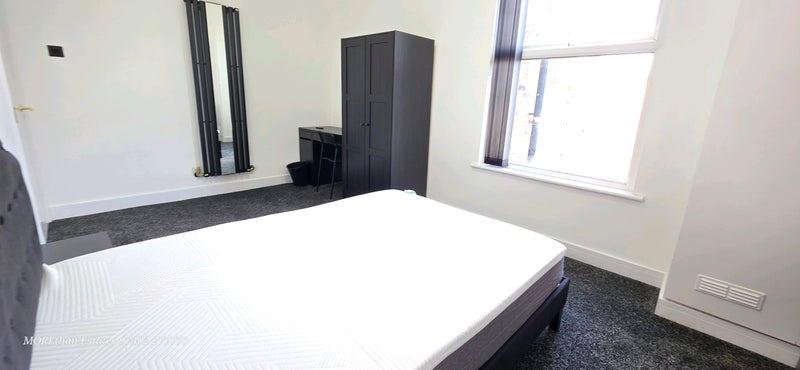 Bright and clean bedroom featuring a comfortabl...