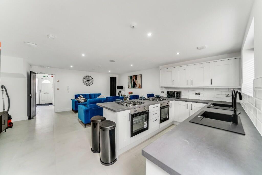 Modern, spacious kitchen featuring sleek white ...