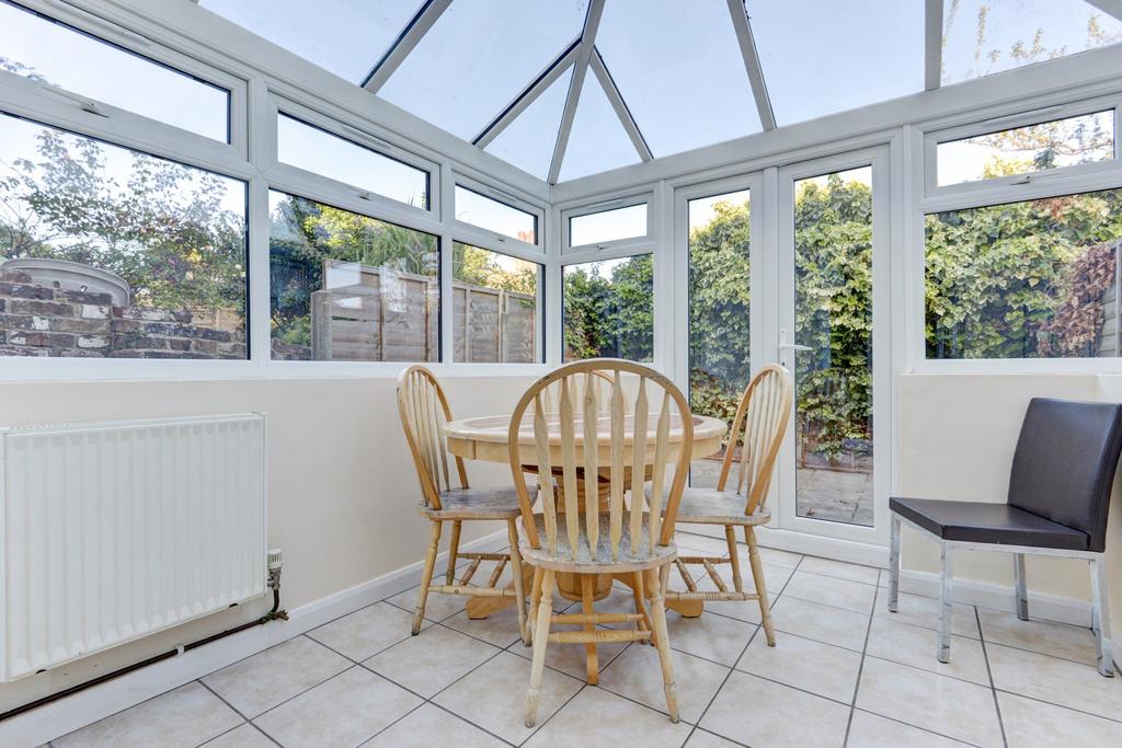 Bright conservatory-style dining area with larg...