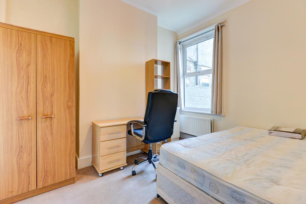 Bright, simply furnished bedroom with a double ...