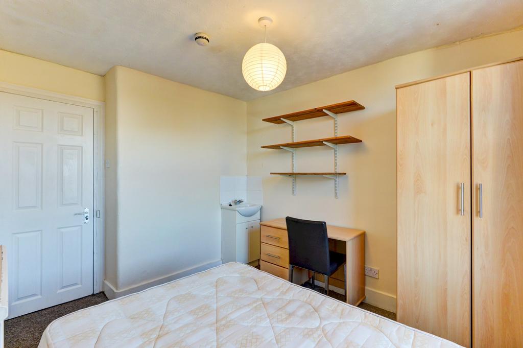 Bright, neatly presented bedroom featuring a do...