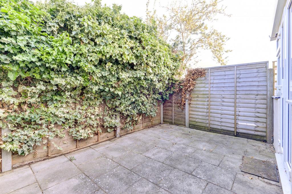 Private paved patio with high fencing and a lea...