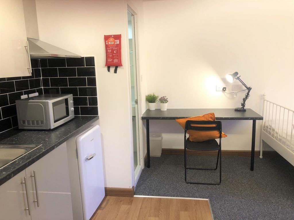 A neat and functional student room featuring a ...