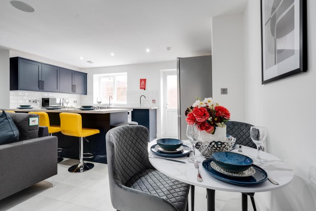 Spacious and modern living room featuring conte...