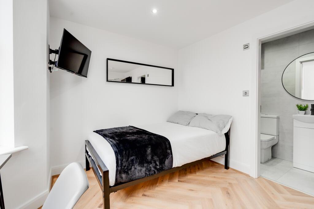 A bright and tidy bedroom featuring a comfortab...