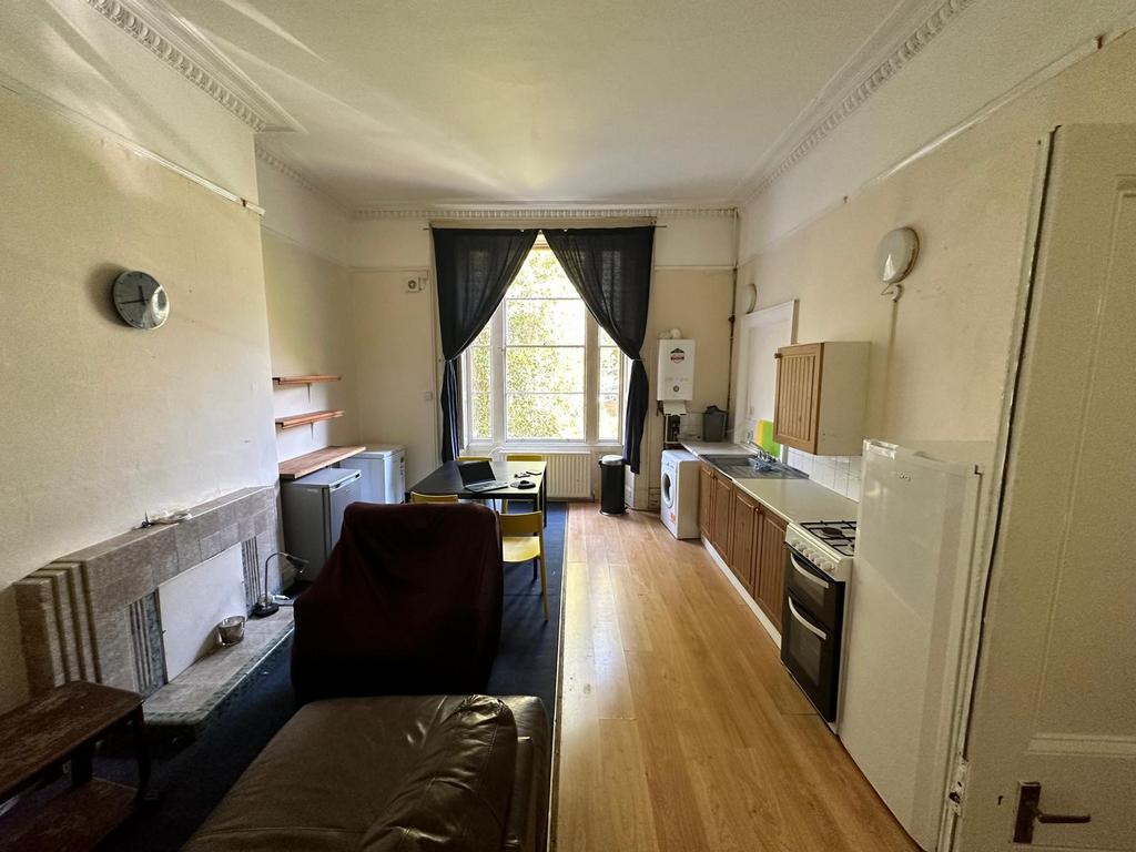 Bright, long open-plan living area with high ce...