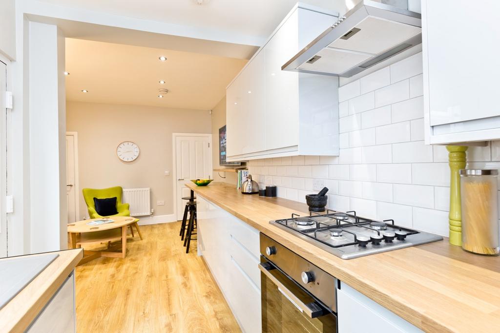 Modern and bright kitchen with white cabinetry,...