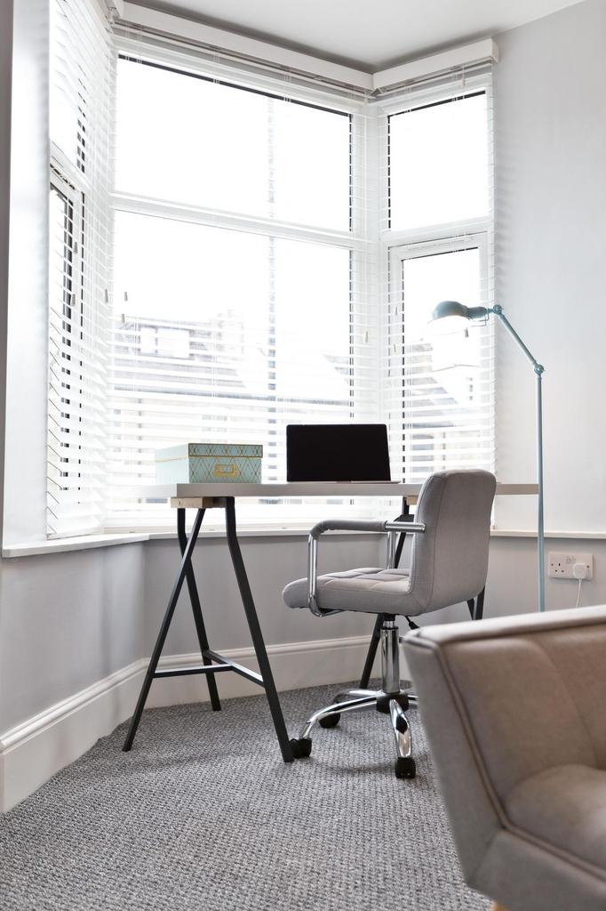 Bright corner workspace with a modern desk and ...