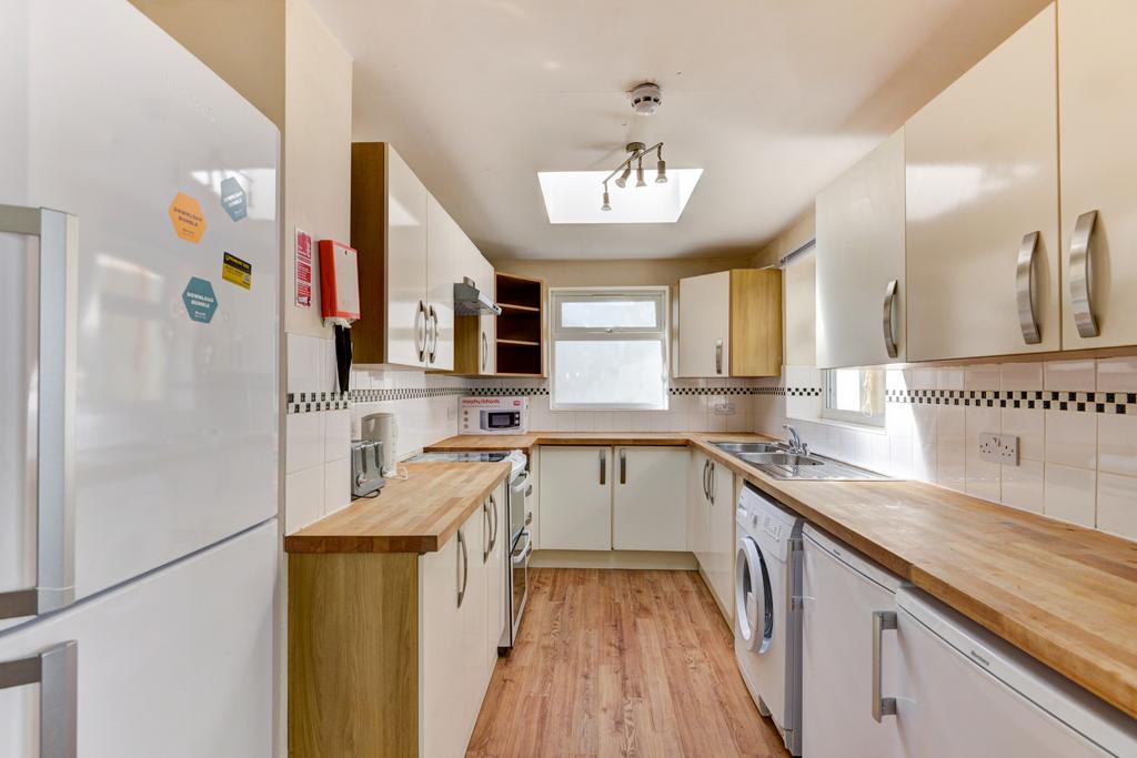 Bright, modern galley kitchen with wooden count...