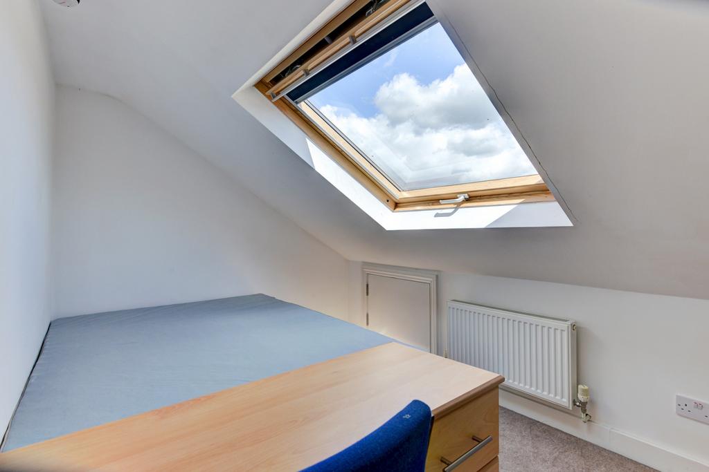 A bright and tidy bedroom featuring a skylight ...