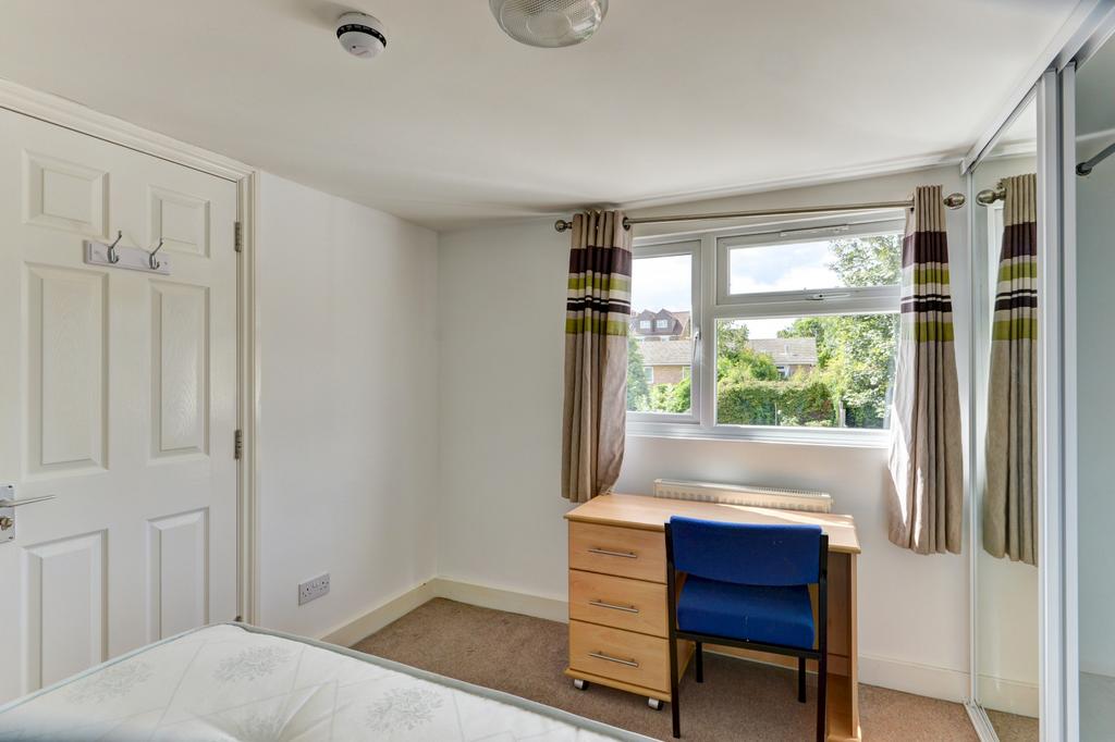 Bright, tidy bedroom with a large window, simpl...