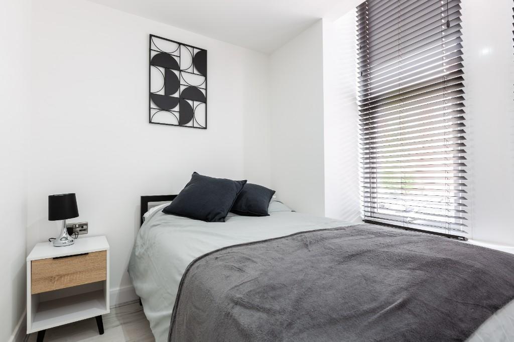 A bright and tidy single bedroom with a comfort...