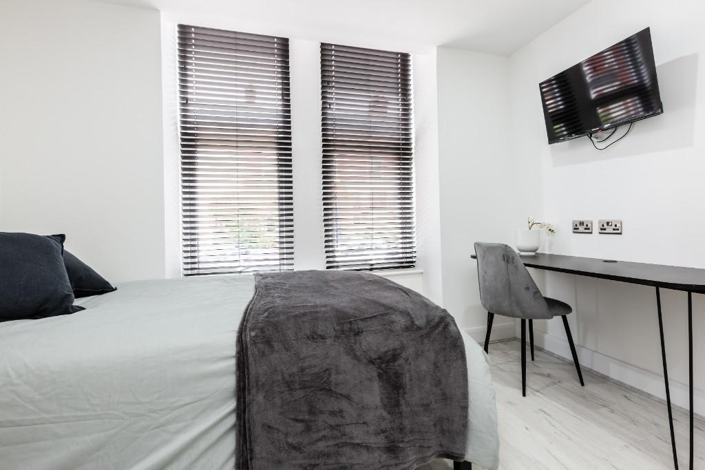 A modern, bright bedroom featuring large window...