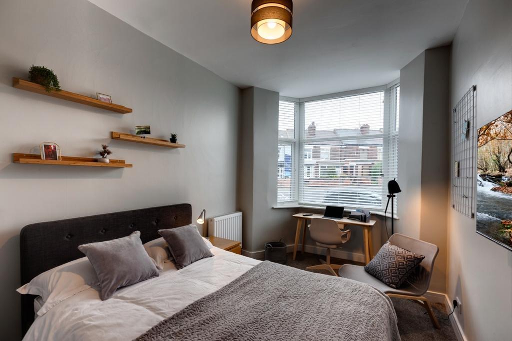 Bright, well-styled bedroom with a comfortable ...