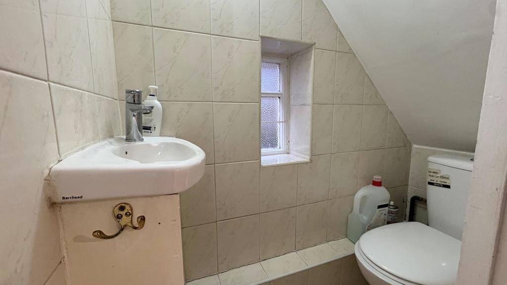 Compact, well-kept bathroom with tiled walls, a...