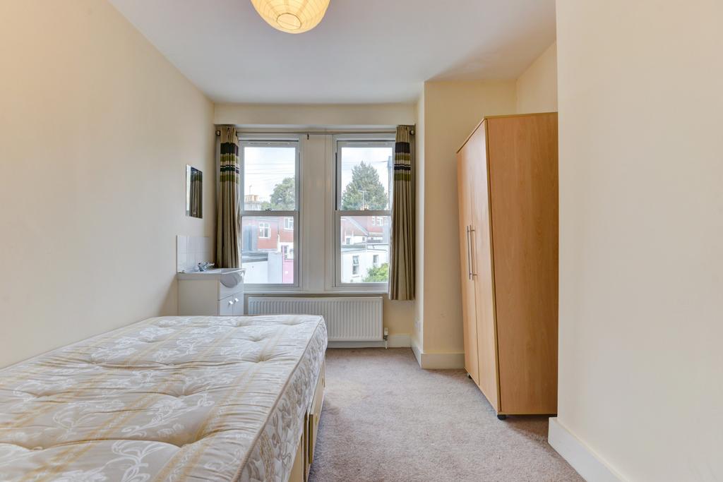 A bright and tidy bedroom featuring a single be...