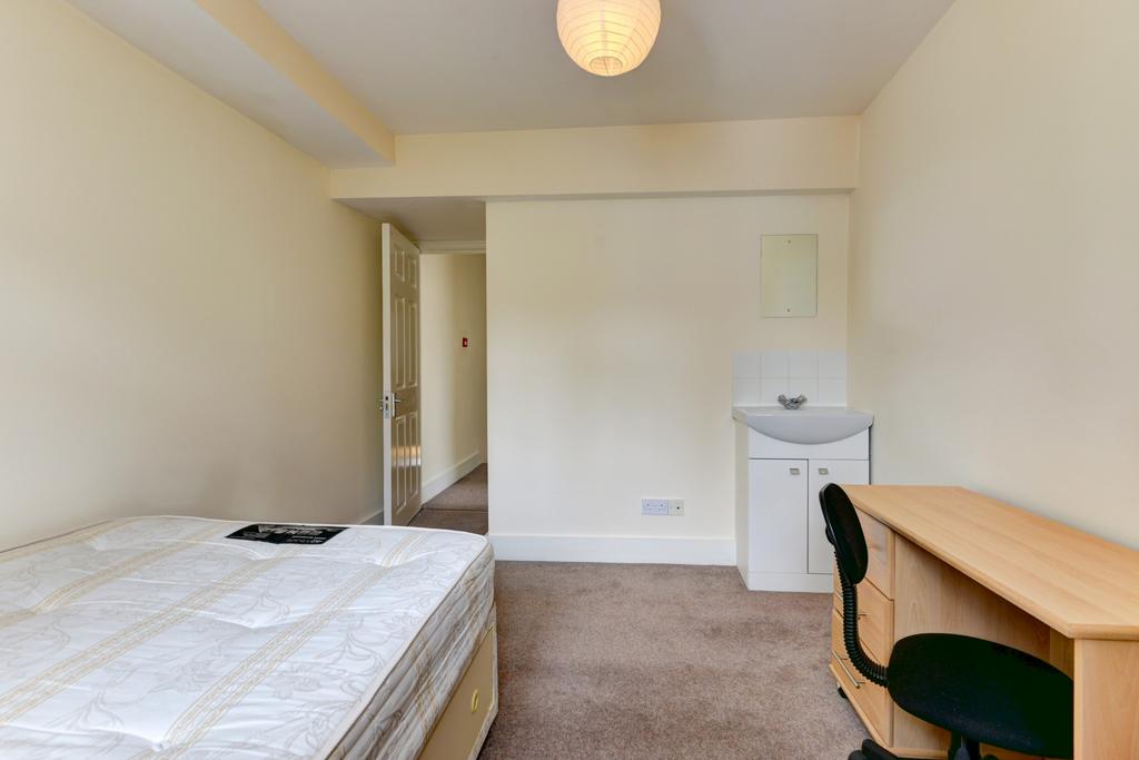 Bright, simply furnished bedroom with a double ...