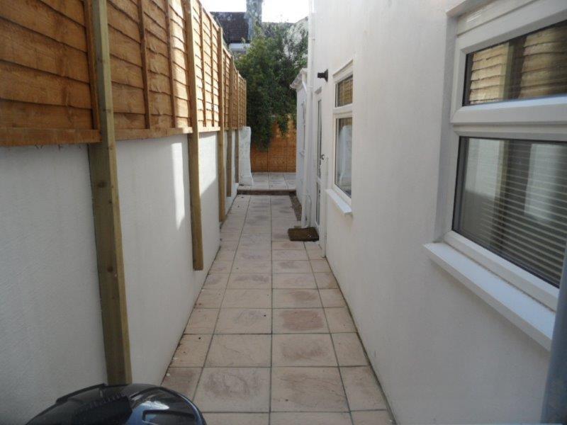 Narrow paved side passage alongside a property ...
