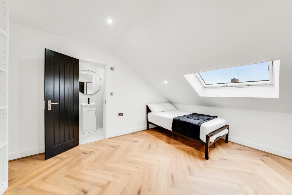 A bright, spacious master bedroom with a modern...