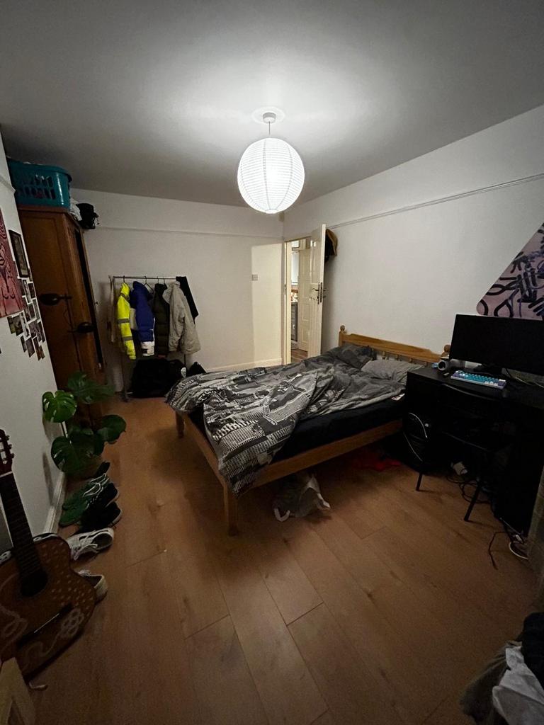 Bright, simply furnished bedroom with wooden fl...