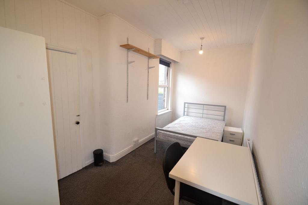 A compact single bedroom featuring a metal bed ...