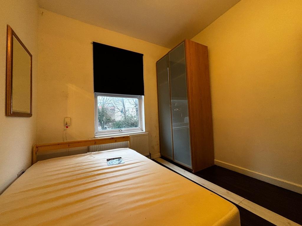 Bright, simply furnished bedroom with a double ...
