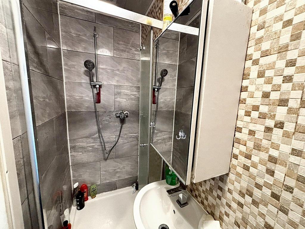 Compact, modern bathroom with tiled shower area...