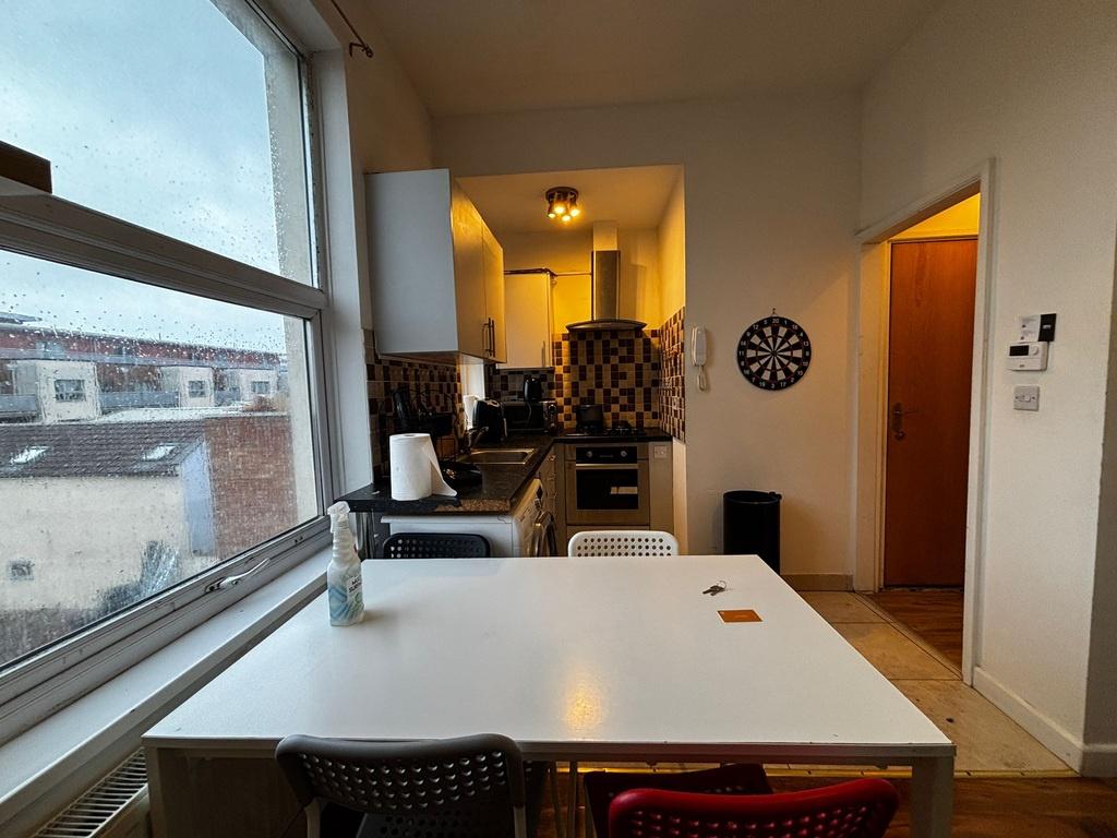 Bright kitchen with a large window, dining tabl...